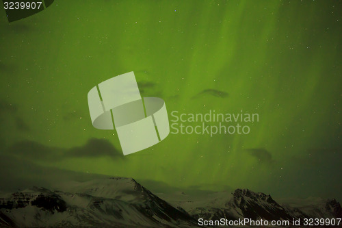 Image of Northern lights with snowy mountains in the foreground