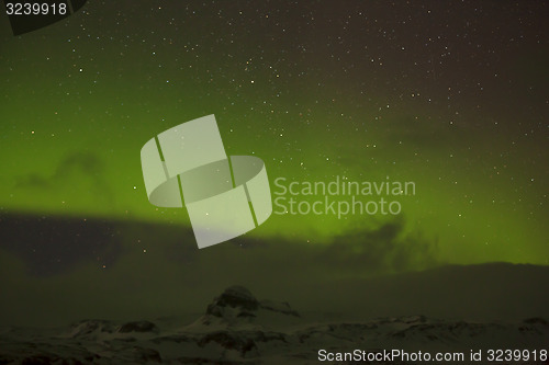 Image of Northern lights with snowy mountains in the foreground