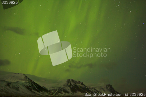 Image of Northern lights with snowy mountains in the foreground