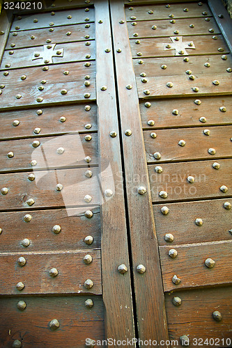 Image of  cross    arsago seprio  brass brown  in a  door curch  italy