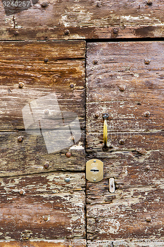 Image of castellanza   knocker in a  door curch  closed    cross