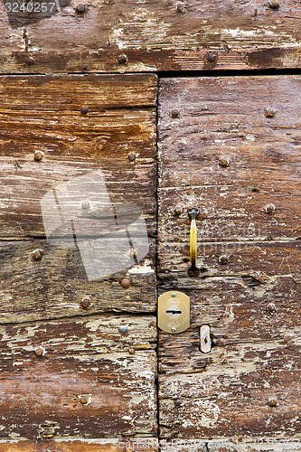 Image of castellanza   knocker in a  door curch  closed    cross