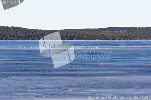 Image of Fishermen on the ice fishing on the frozen lake