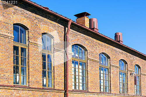 Image of Retro red brick house wall with windows
