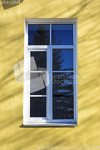 Image of Old window on yellow wall