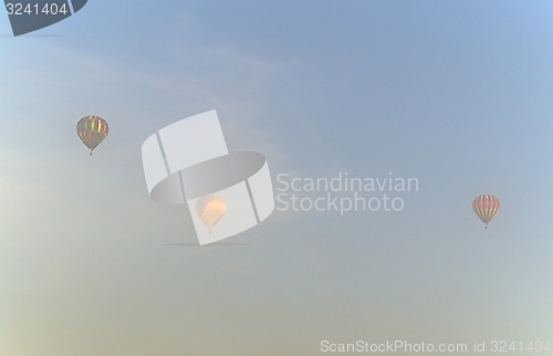 Image of three hot air balloons in the morning mist