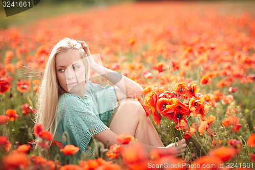 Image of Beautiful woman on poppy flower field