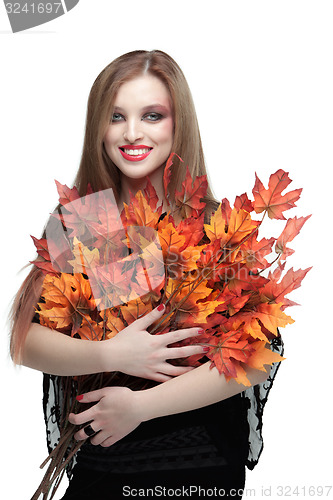 Image of Smiling young woman with autumn maple leaves 