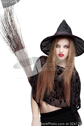 Image of Showy young woman in witch costume with a broom