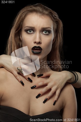 Image of Pretty gothic  brunette woman with hands on neck