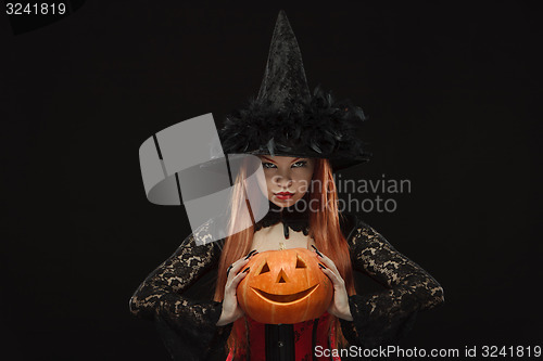 Image of Girl with Halloween pumpkin on black background