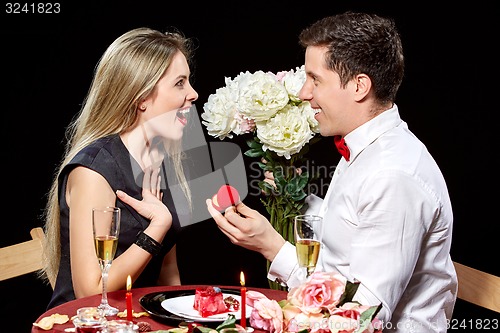 Image of Man proposing marriage to a surprised woman