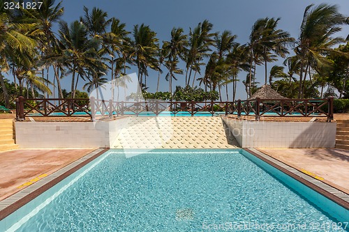 Image of Swimming pool, palm trees and blue sky