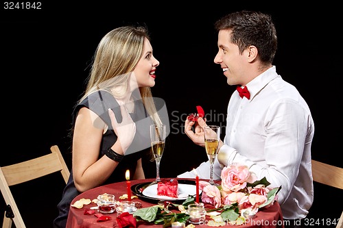 Image of Man proposing marriage to a surprised woman