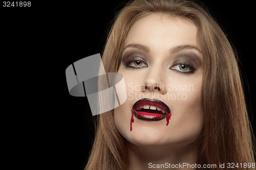 Image of Close-up portrait of a smiling gothic vampire woman
