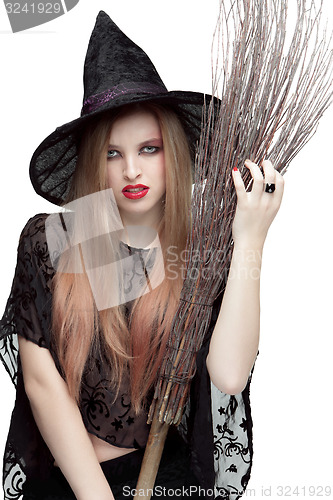 Image of Portrait of young woman in witch costume with a broom