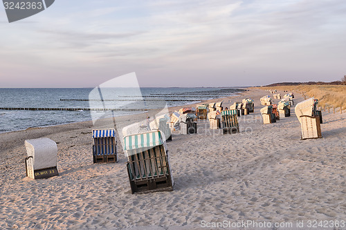 Image of Beach chairs with dunes at sunset