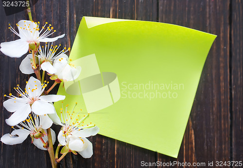 Image of flowers and paper on wooden background