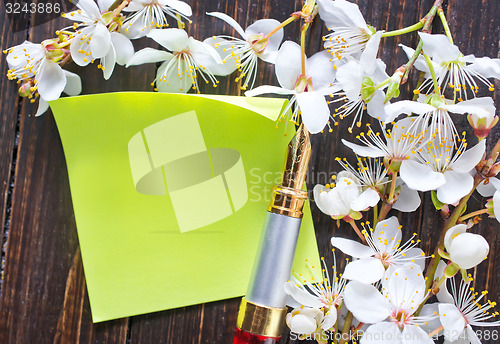 Image of flowers and paper on wooden background