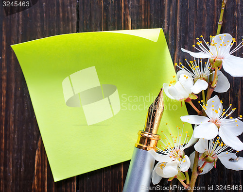 Image of flowers and paper on wooden background