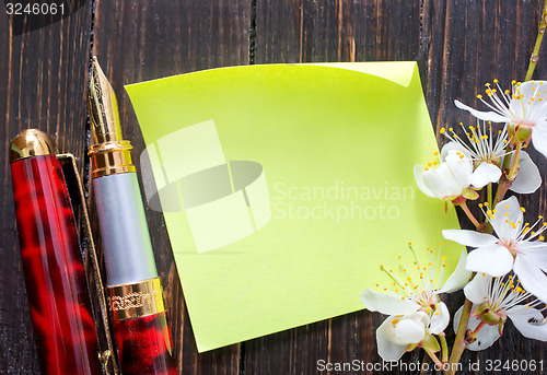 Image of flowers and paper on wooden background