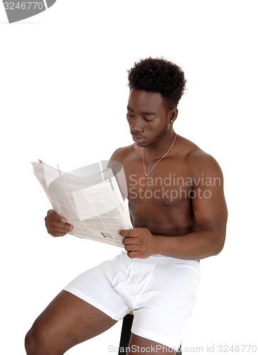 Image of Black man in underwear reading.