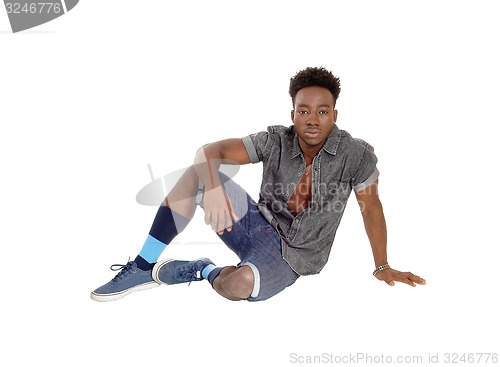 Image of Black man sitting on floor.