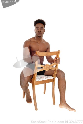 Image of Black man sitting on chair.