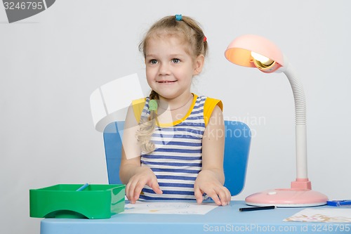 Image of Four-year girl picks up a picture