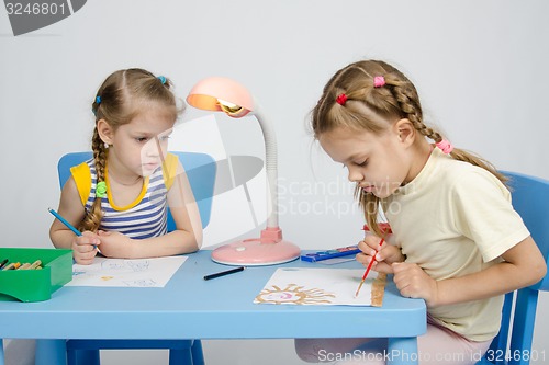 Image of Girl watching sister draws paints
