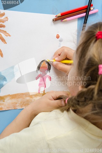 Image of Girl draws a pencil on drawing painted colors