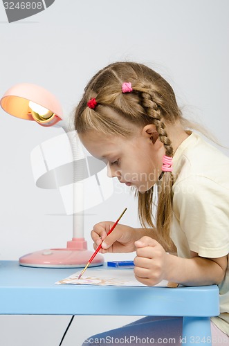 Image of Six year old girl with enthusiasm draws paints