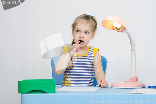 Image of Girl thinking stuck a pencil in her mouth