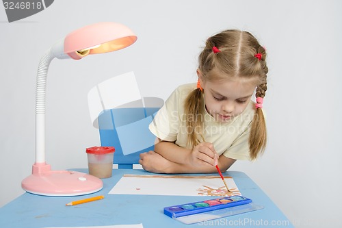 Image of Girl paints sitting at the table