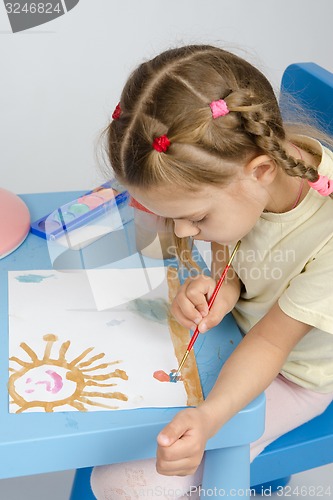 Image of Six year old girl draws a paint something in the picture