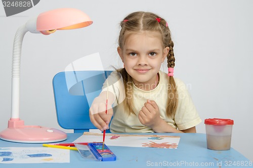 Image of Six year old girl dunks brush in the paint