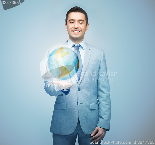Image of happy businessman in suit showing globe hologram