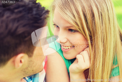 Image of smiling couple looking at each other in park