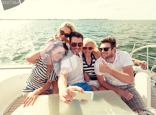 Image of smiling friends sitting on yacht deck