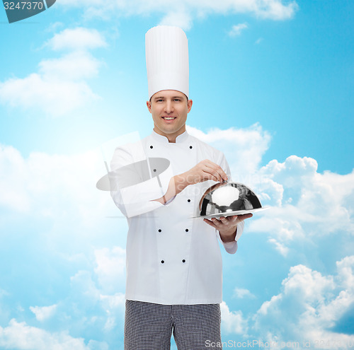 Image of happy male chef cook holding cloche