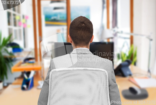 Image of businessman sitting in office chair from back