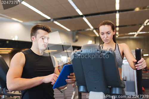 Image of woman with trainer exercising on stepper in gym