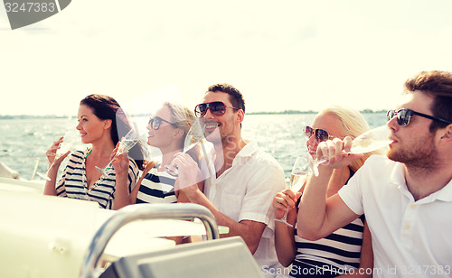 Image of smiling friends with glasses of champagne on yacht