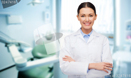 Image of happy young female dentist with tools