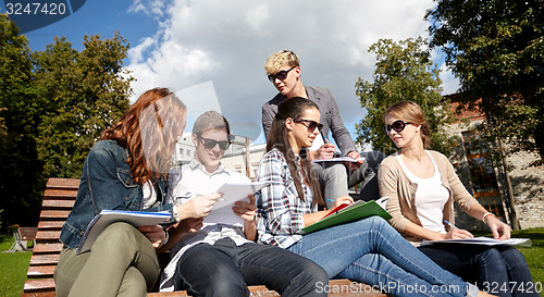 Image of group of happy students with notebooks at campus
