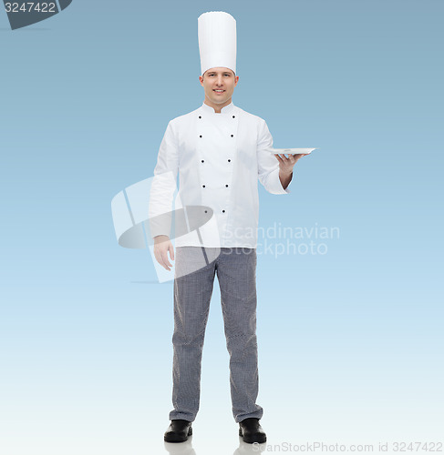 Image of happy male chef cook showing empty plate