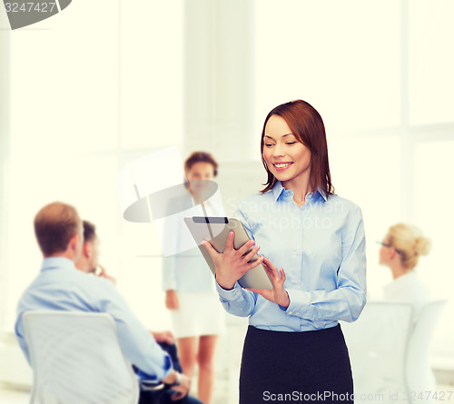 Image of smiling woman looking at tablet pc at office