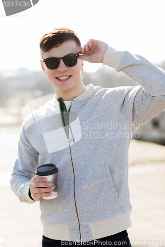 Image of smiling young man or boy drinking coffee