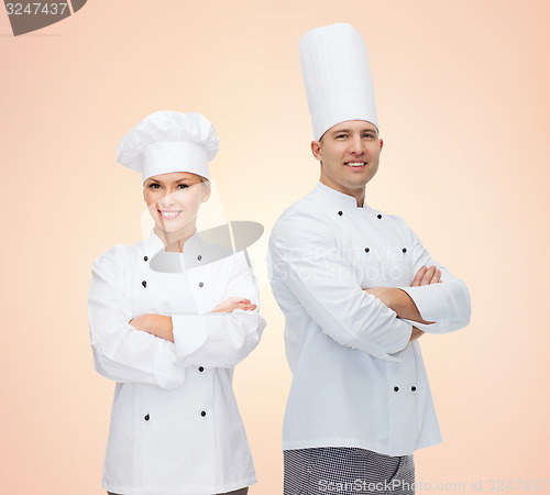 Image of happy chefs or cooks couple over beige background