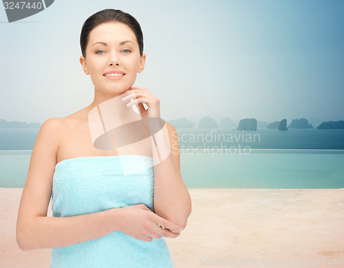 Image of beautiful woman in towel over infinity pool